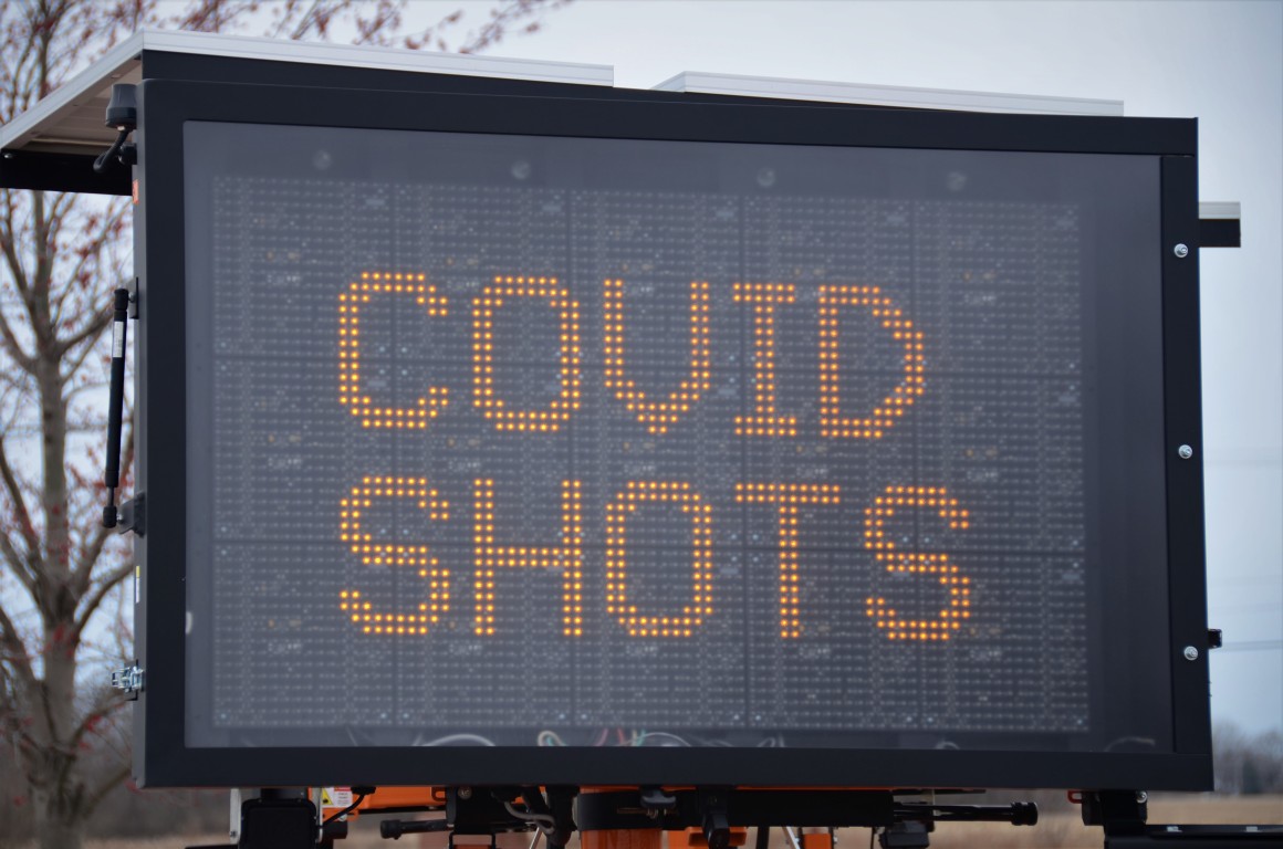Electronic billboard with COVID shots on it