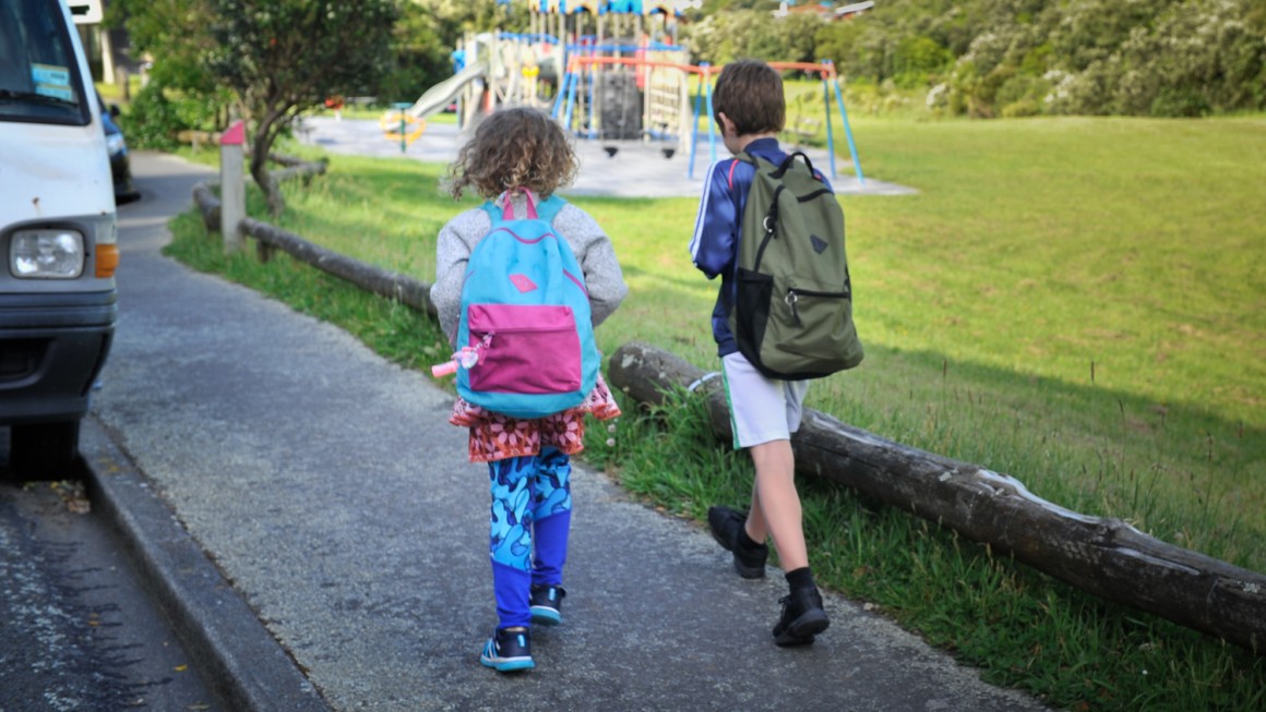 Back view of young children walking to school 