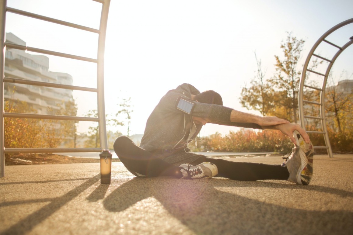 Man sitting stretching outside