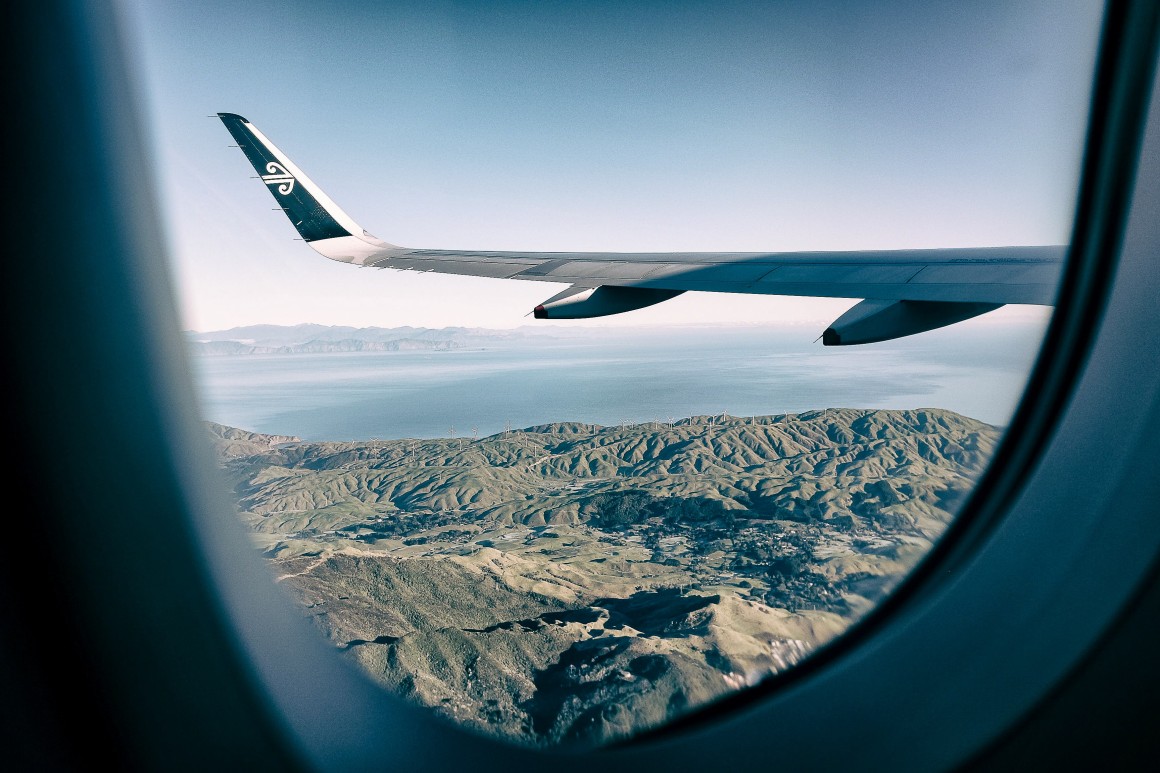 Looking out airplane window to wing and vista