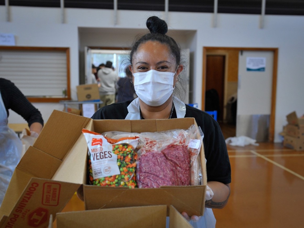 A woman showing a box of food - COVID