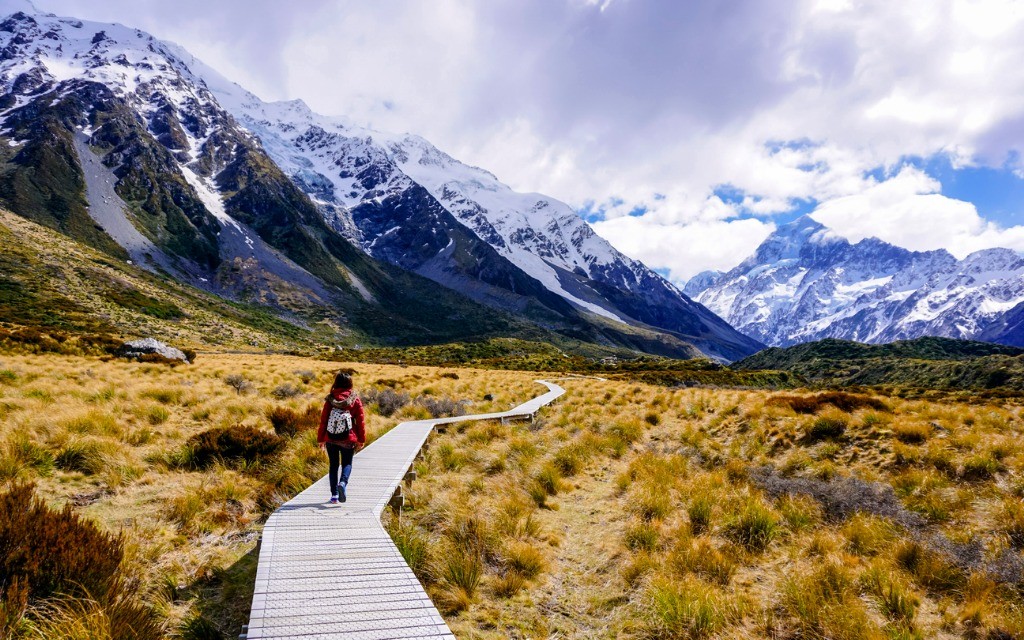 Woman walking track towards mt Cook, Aotearoa