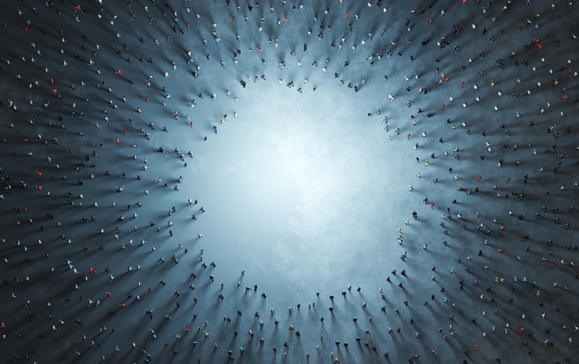 sky view of lots of people surrounding a hole