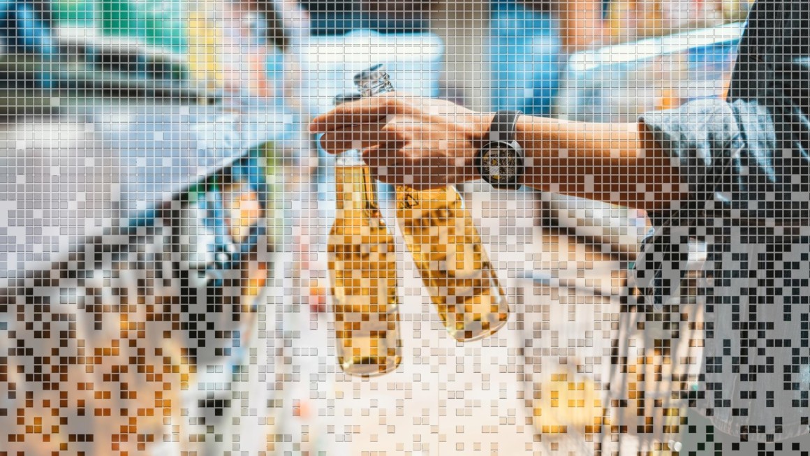 Image of hand taking beer bottles off shelf in store