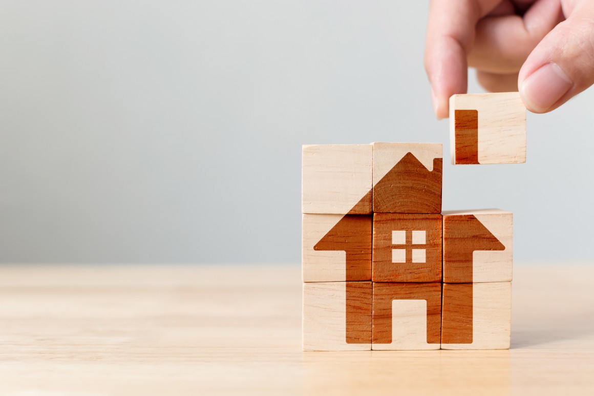 1 Wooden housing puzzle - piece being added