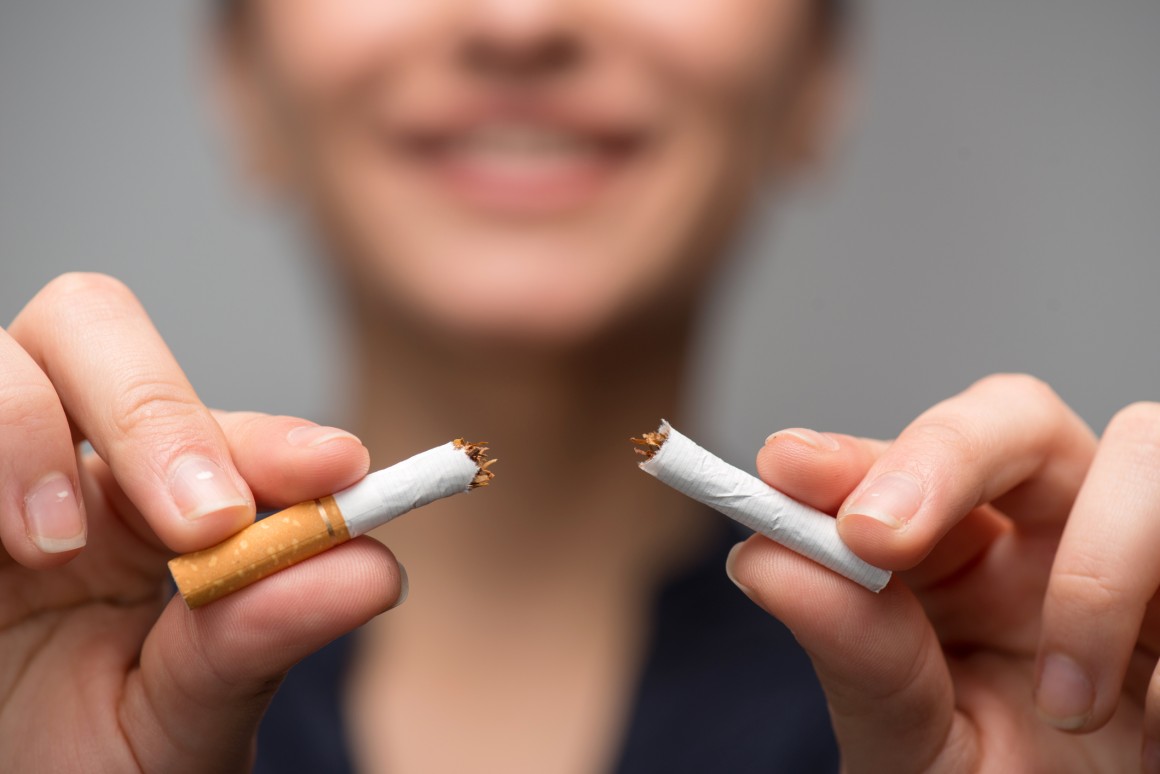 woman breaking a cigarette and smiling