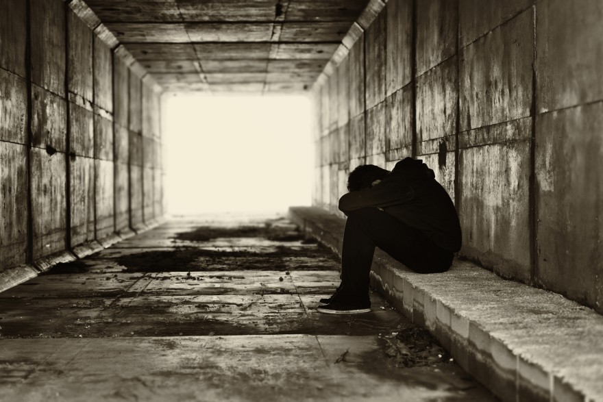 Young homeless person in underpass in black and white