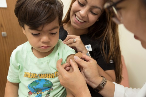 Boy getting vaccination with caregiver 