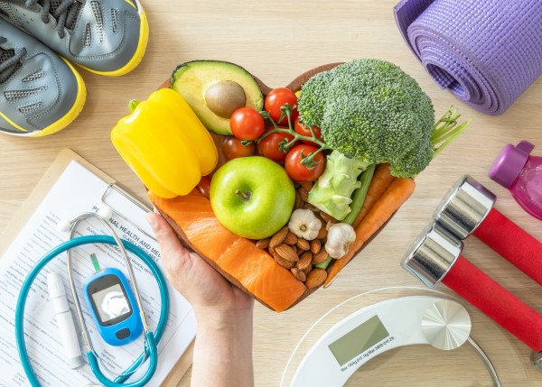 heart shaped platter with nutritious food and fitness equipment scattered around