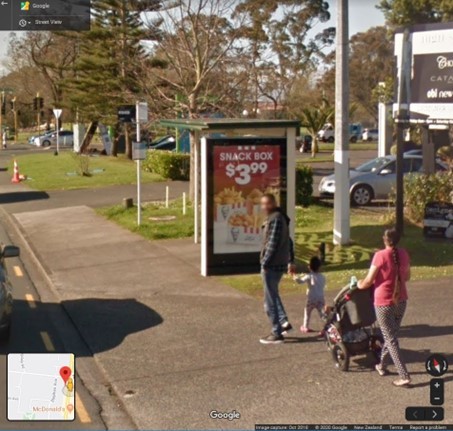 people with children walking past junk food advertising from maps