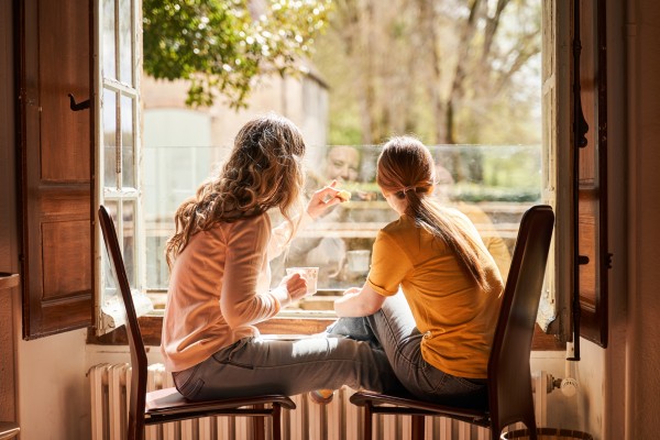 Young girls nd woman looking out a window