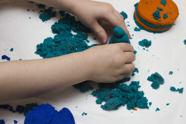 Childs hands playing with coloured sand