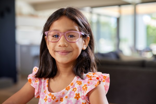 Young girl wearing glasses with a bright t-shirt.